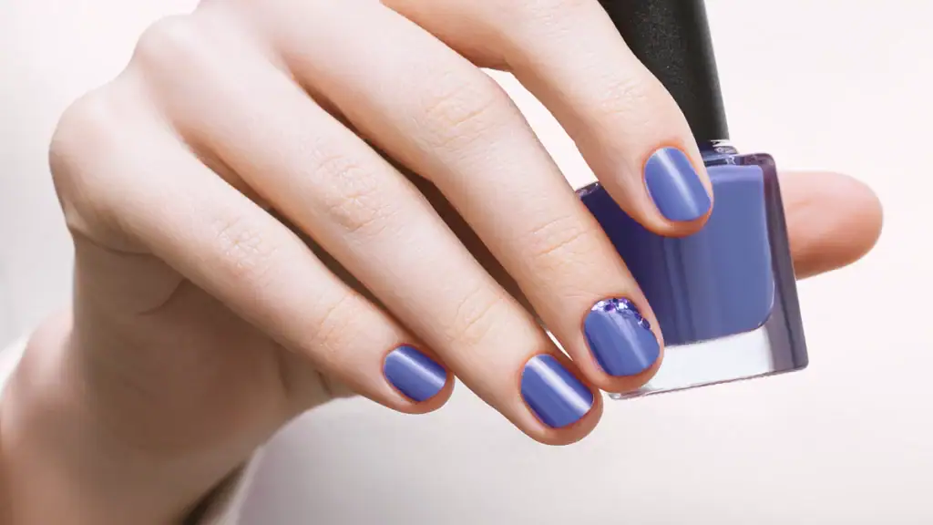 Vernis semi-permanent bleu appliqué sur des ongles soignés pour une tenue longue durée.